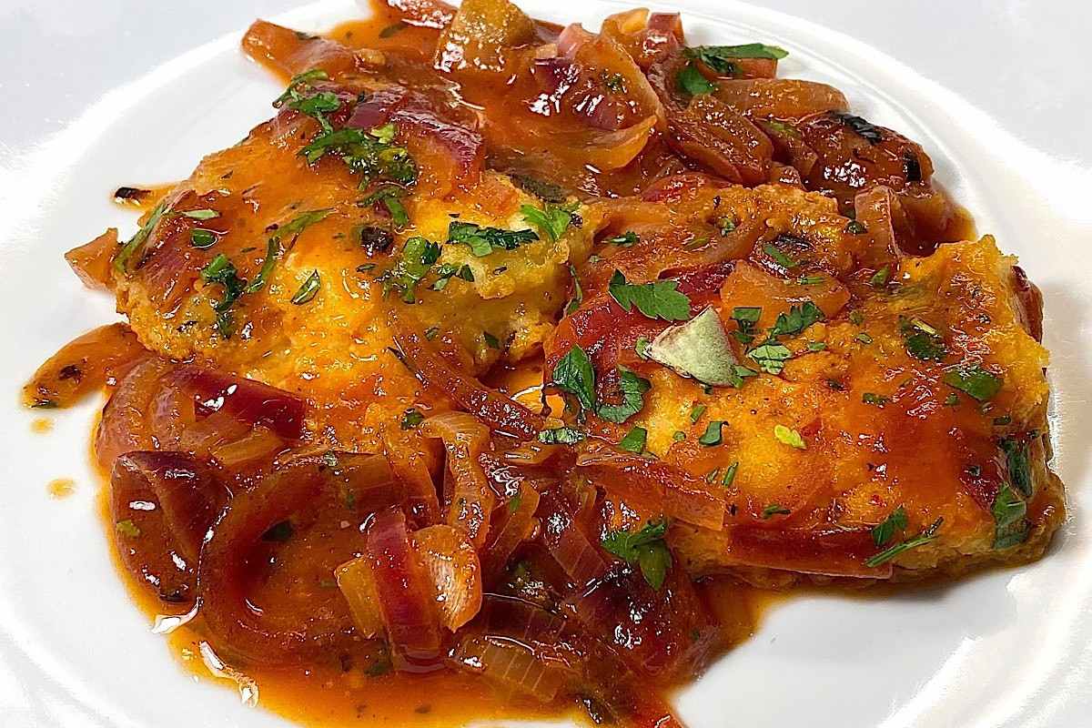 baccalà con cipolle in piatto bianco